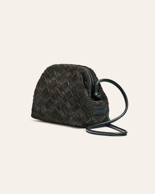 Dark green suede woven handbag with a strap on a light gray background