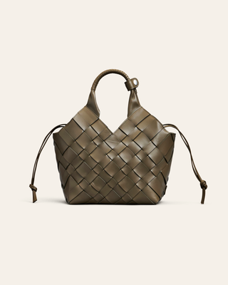 Cala Jade misu medium grenn woven leather handbag on a light beige background