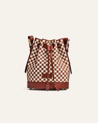 Checkered bucket bag with brown leather accents on a white background