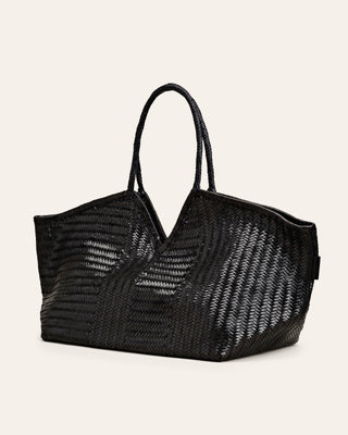 A black leather tote bag with a v-shaped cutout on top and slender handles.