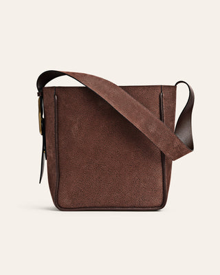 Brown leather crossbody bag on a beige background
