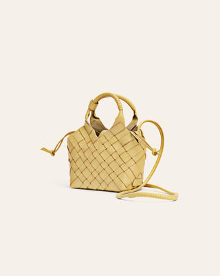 Cala Jade Misu Mini Small woven yellow handbag on a light beige background seen from the side