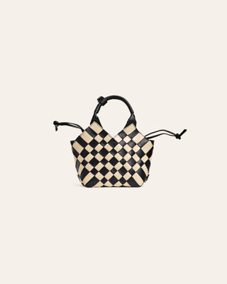 Black and white leather checkered bag on a beige background