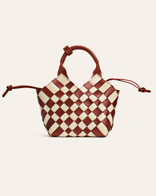 Checkered handbag with brown and white pattern on a light beige background