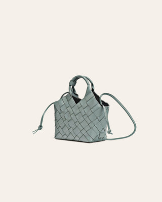 Light blue woven handbag on a light beige background side image