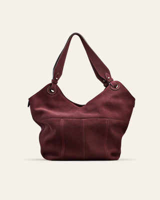 Burgundy leather suede handbag on a light beige background