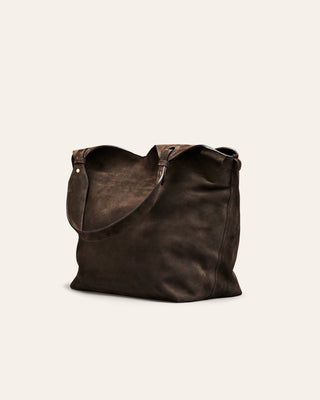 Brown leather tote bag on a light beige background