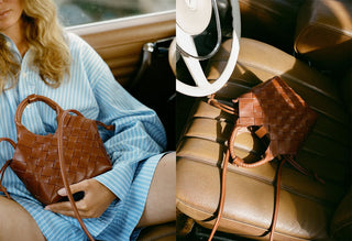 Brown woven handbag held by a person in a car interior.