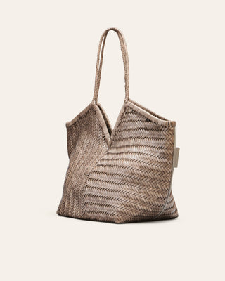 Cala Jade grey woven shoulder bag  seen from the side on a beige background