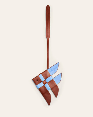 Cala Jade blue and brown leather bag charm shaped as a fish on a beige background