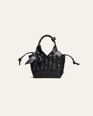 Black woven handbag with flower leather charm on a light gray background