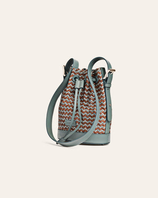 Brown and blue bucket bag with patterned top and solid base on a light gray background