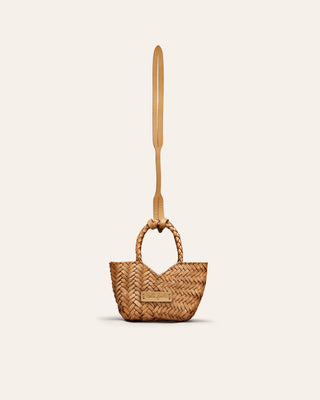 A beige leather bag charm on a beige background
