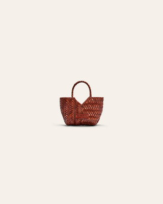 A brown woven leather bag charm on a beige background