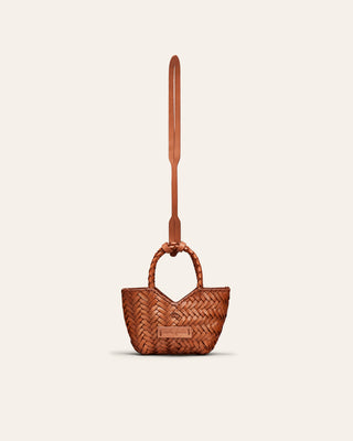 A red leather bag charm on a beige background