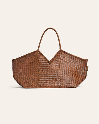 Large woven brown bag on a beige background