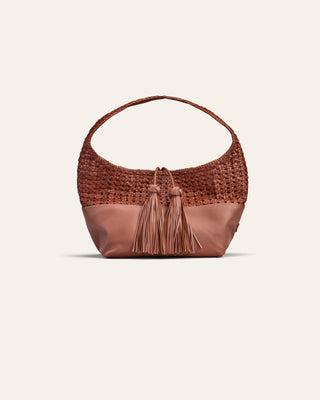 Coral woven handbag with tassel on a beige background