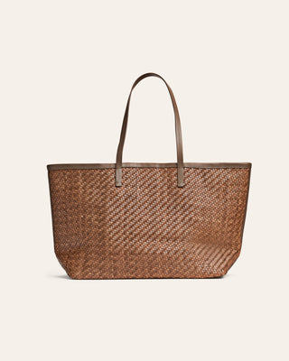 Brown woven leather shopper bag with handle on a beige background