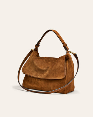 A brown suede shoulder bag with a top handle and a detachable shoulder strap, shown on a plain off-white background.