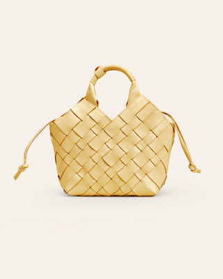 Woven yellow handbag on a light beige background