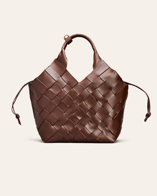 A brown woven leather handbag with a structured basketweave pattern, a single top handle, and thin leather side ties, shown against a plain light beige background.
