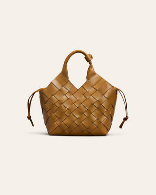 Cala Jade sepia brown hand woven leather bag on a beige backgrpund