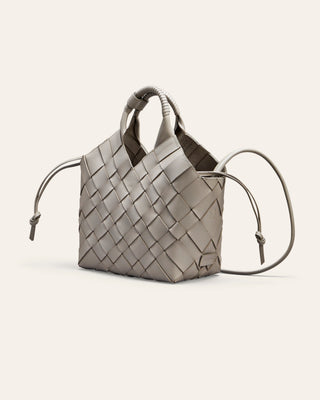 A grey woven leather handbag on a light gray background