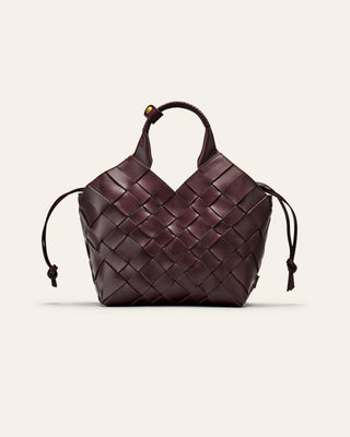 A burgundy woven leather bag on a beige background