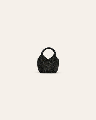 Black textured handbag charm on a light beige background