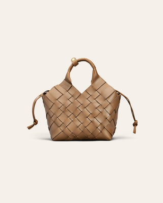 A small woven leather handbag in tan, featuring a structured basketweave pattern, a top handle with a decorative bead, and drawstring ties on the sides, shown against a solid off-white background.