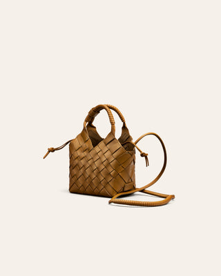 Woven brown leather handbag on a light beige background