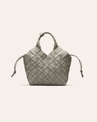 A grey woven leather bag on a beige background