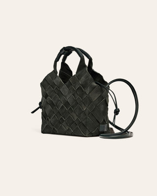 Dark green suede woven handbag with a strap on a light beige background