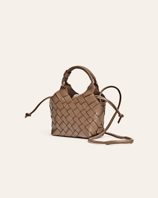 Dark beige woven handbag on a light beige background