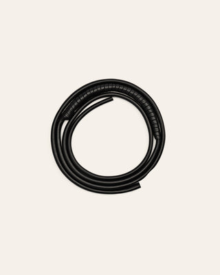 A black leather shoulder strap on a beige background