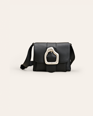 Black handbag with a silver clasp on a light beige background