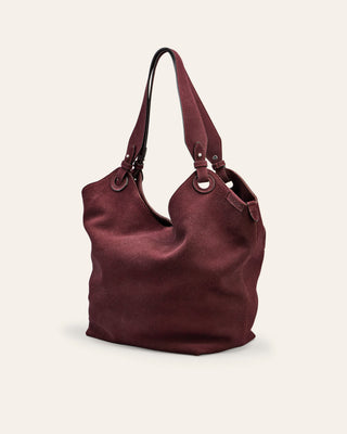 Burgundy suede handbag on a beige background
